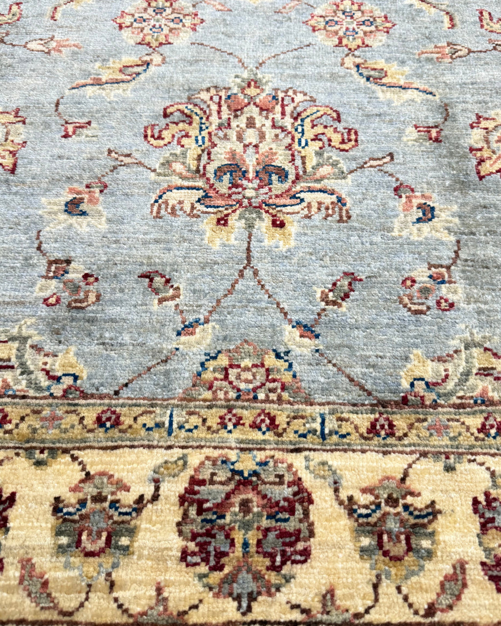 Tappeto Choobi 146x101 cm azzurro con bordura crema e motivi floreali