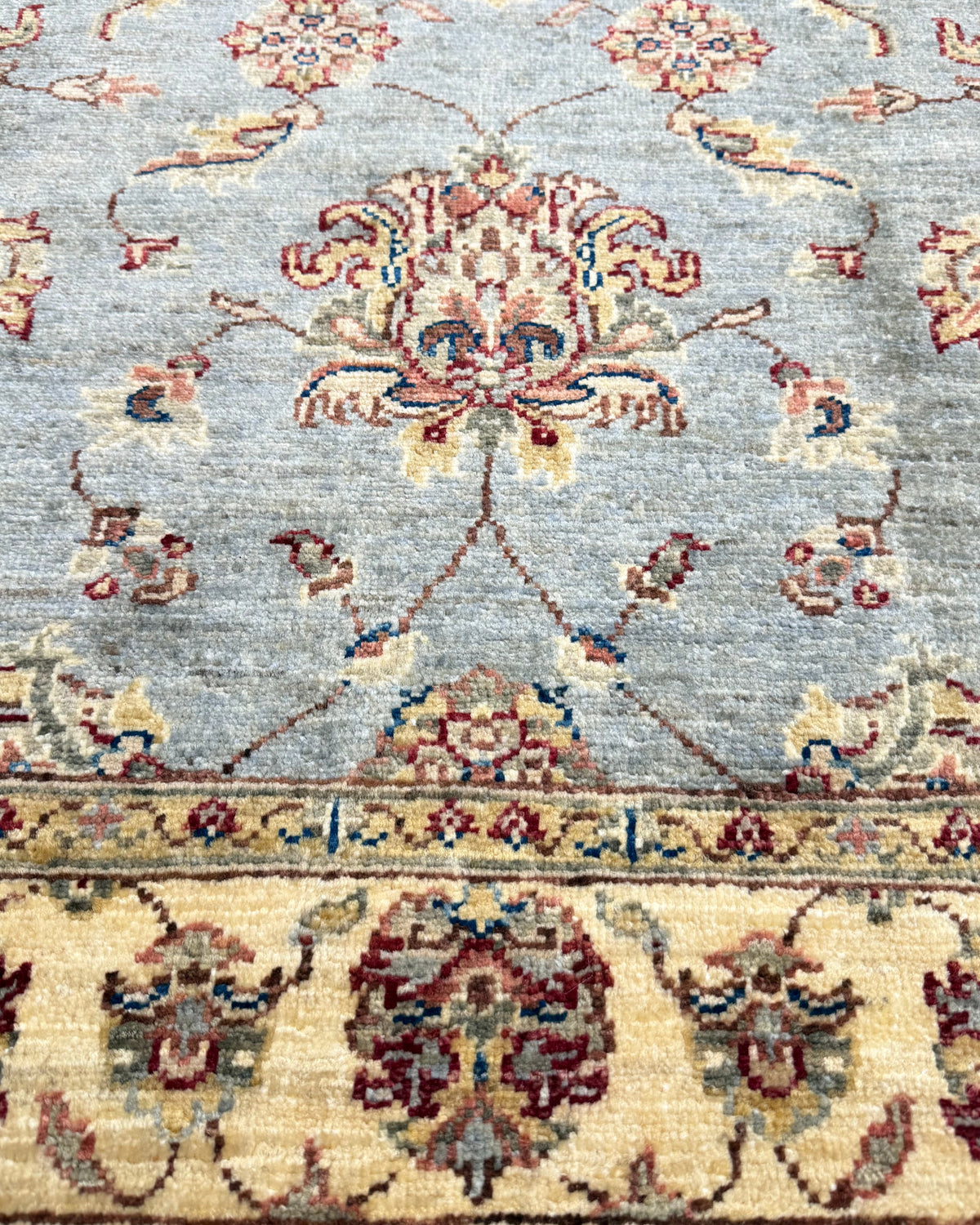 Tappeto Choobi 146x101 cm azzurro con bordura crema e motivi floreali