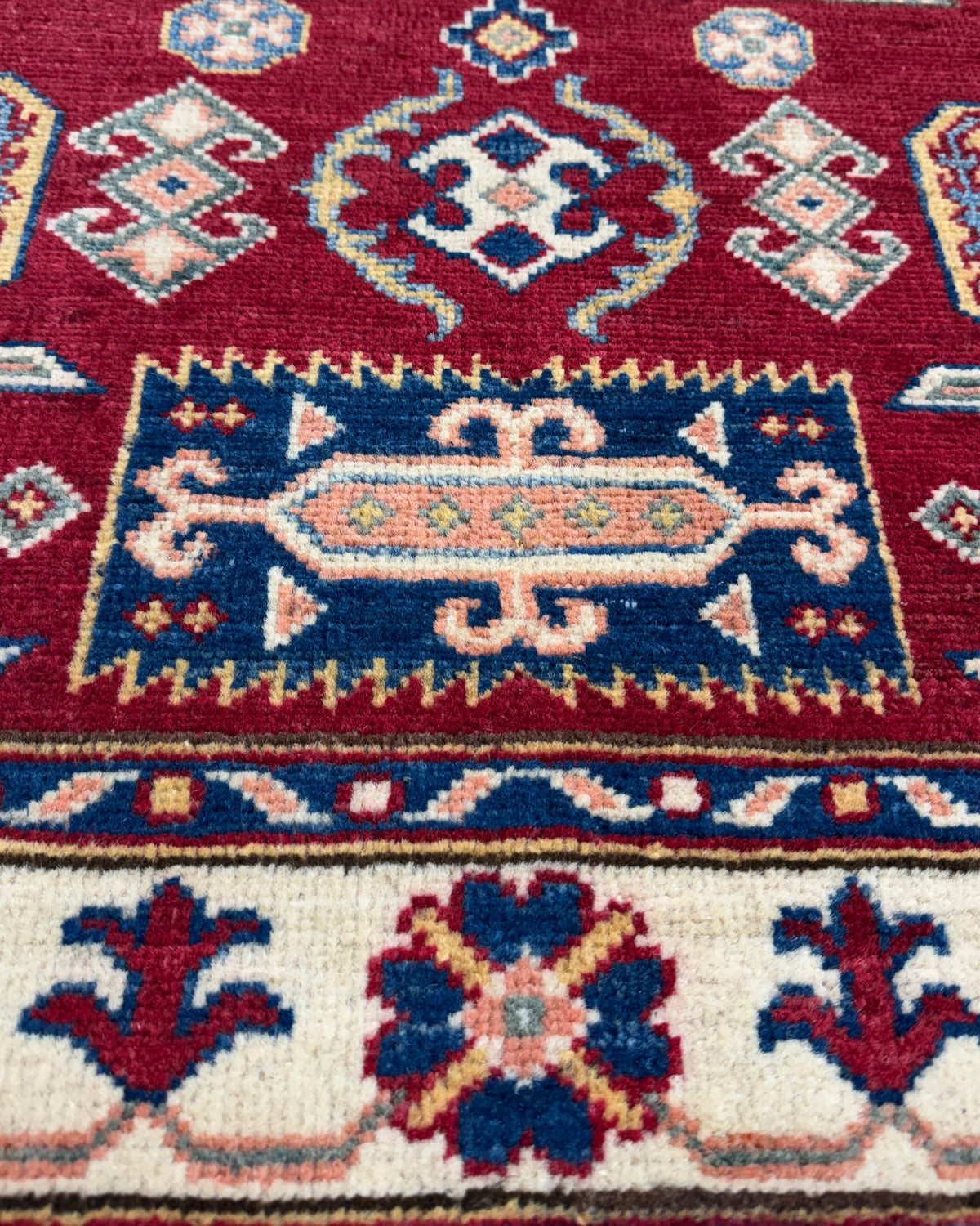 Tappeto Uzbek 144x98 cm rosso con motivi geometrici blu e avorio