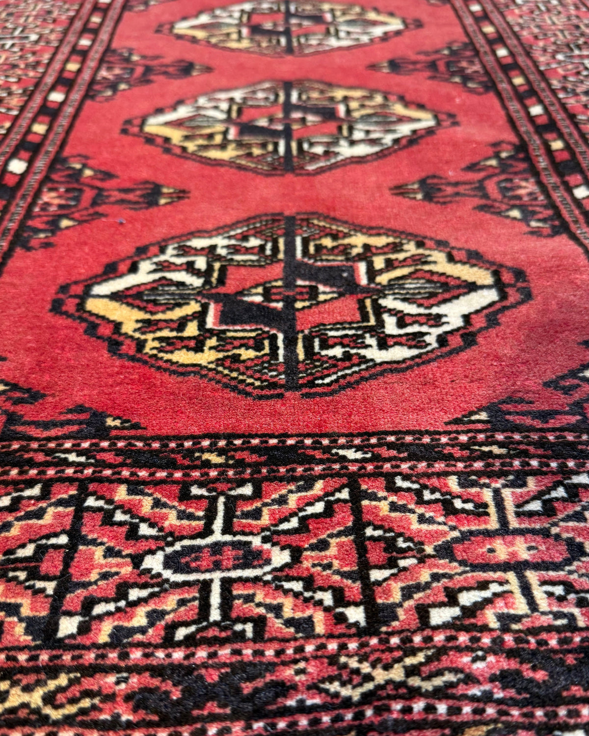 Bukhara Russo 90x62 cm - coppia di scendiletto in lana con fondo rosso e motivi geometrici