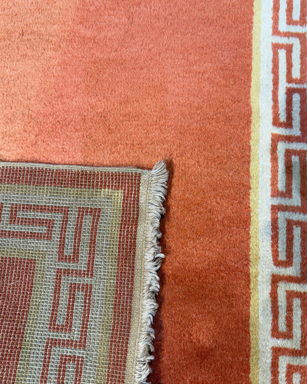 Pechino 92x61 cm - coppia di scendiletto annodati a mano con fondo arancio e bordura geometrica