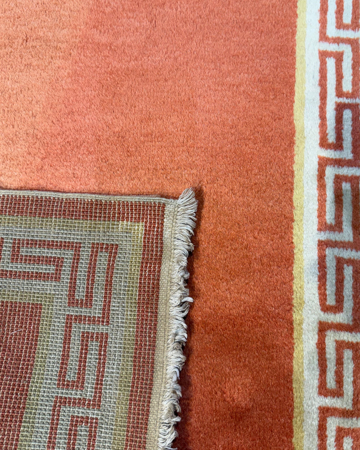 Pechino 92x61 cm - coppia di scendiletto annodati a mano con fondo arancio e bordura geometrica