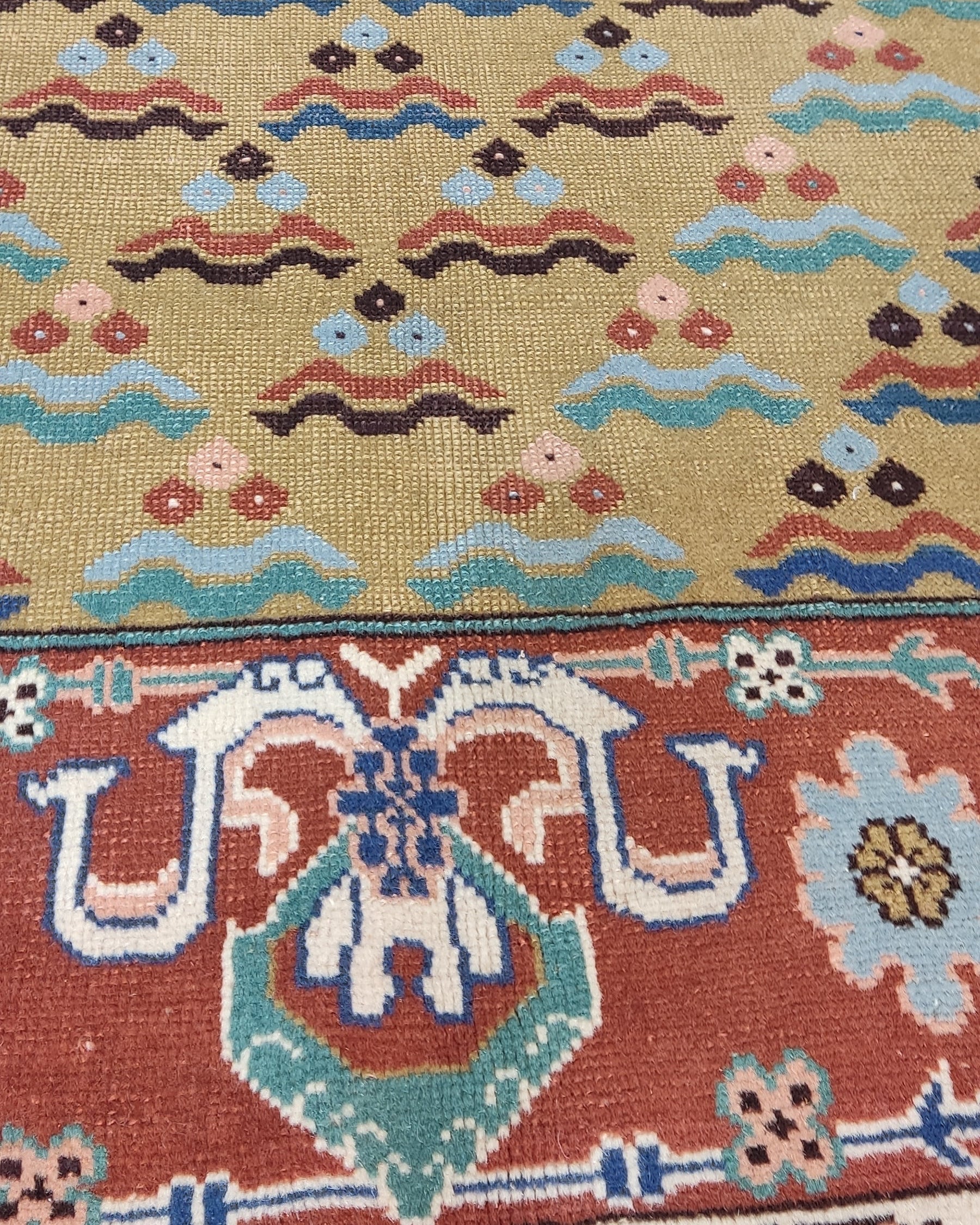 Tappeto Anatolia annodato a mano con campo avorio dorato e bordura decorativa nei toni del rosso terracotta e azzurro, misura 170x120 cm