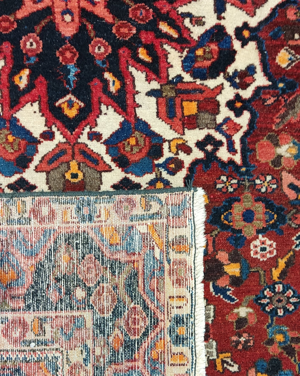 Tappeto persiano Bakhtiari annodato a mano con medaglione geometrico centrale su fondo rosso, misura 255x155 cm
