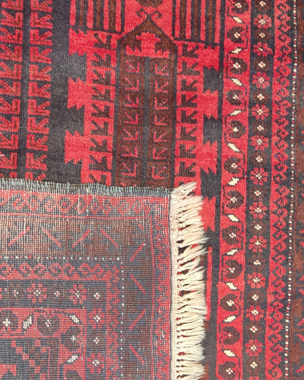 Tappeto Beluch persiano annodato a mano con motivi geometrici tribali nei toni del rosso e bordeaux, misura 200x125 cm
