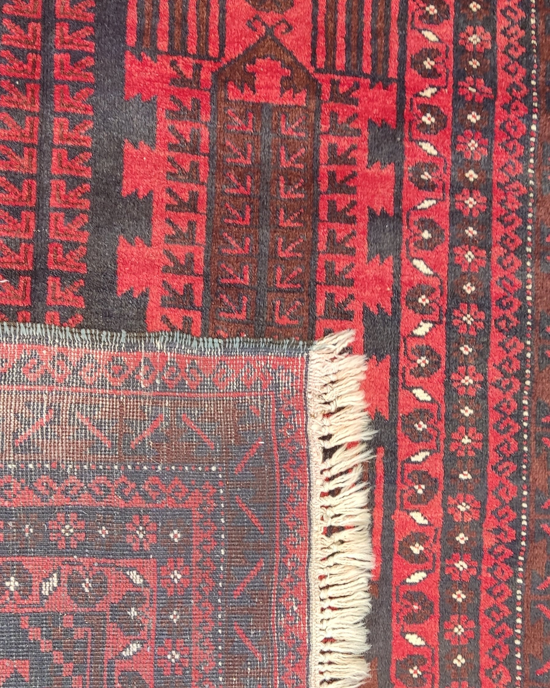 Tappeto Beluch persiano annodato a mano con motivi geometrici tribali nei toni del rosso e bordeaux, misura 200x125 cm