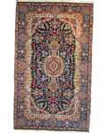 Tappeto Kerman persiano annodato a mano 240x145 cm con medaglione centrale e raffinati motivi floreali su fondo blu notte.