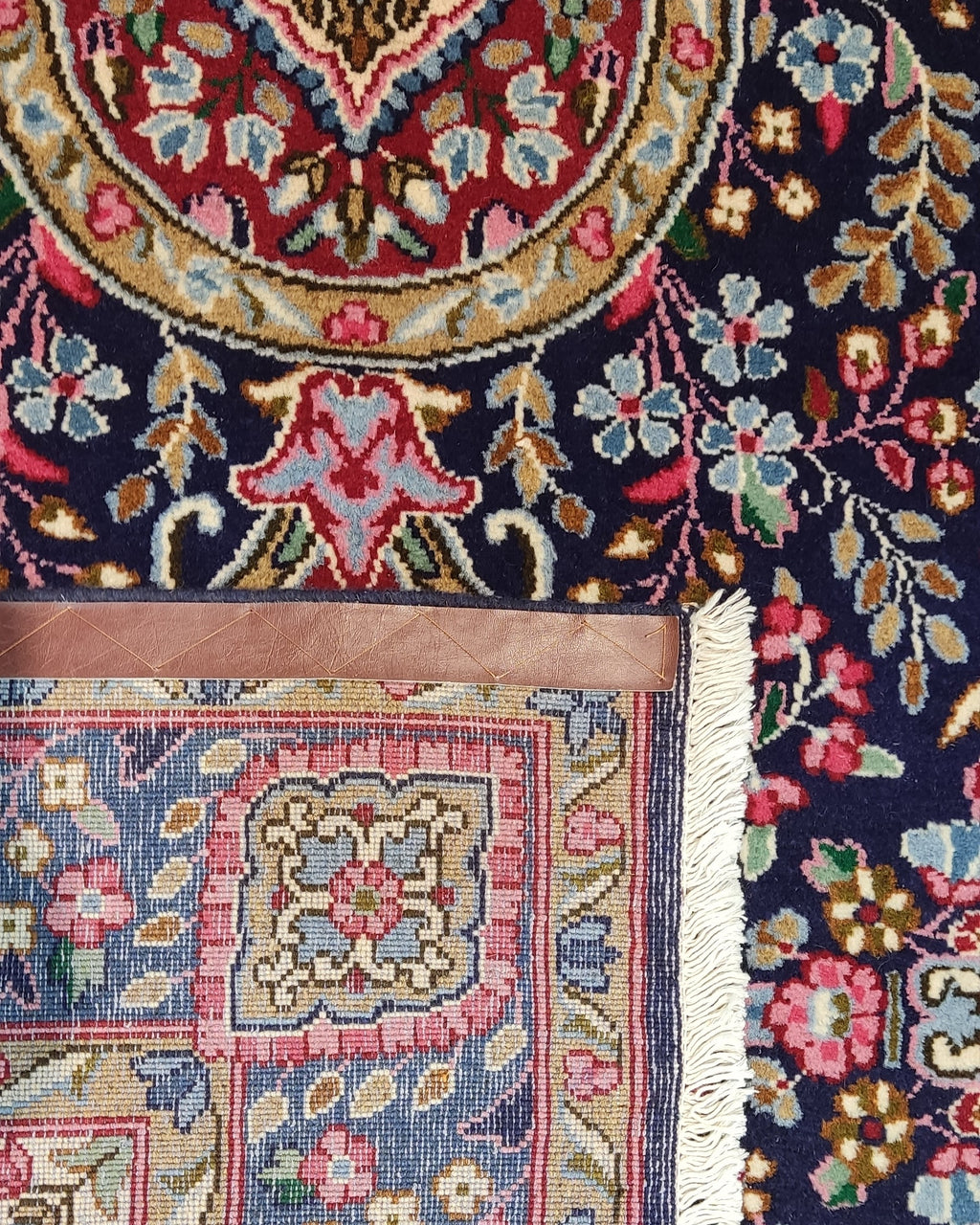 Tappeto Kerman persiano annodato a mano 240x145 cm con medaglione centrale e raffinati motivi floreali su fondo blu notte.
