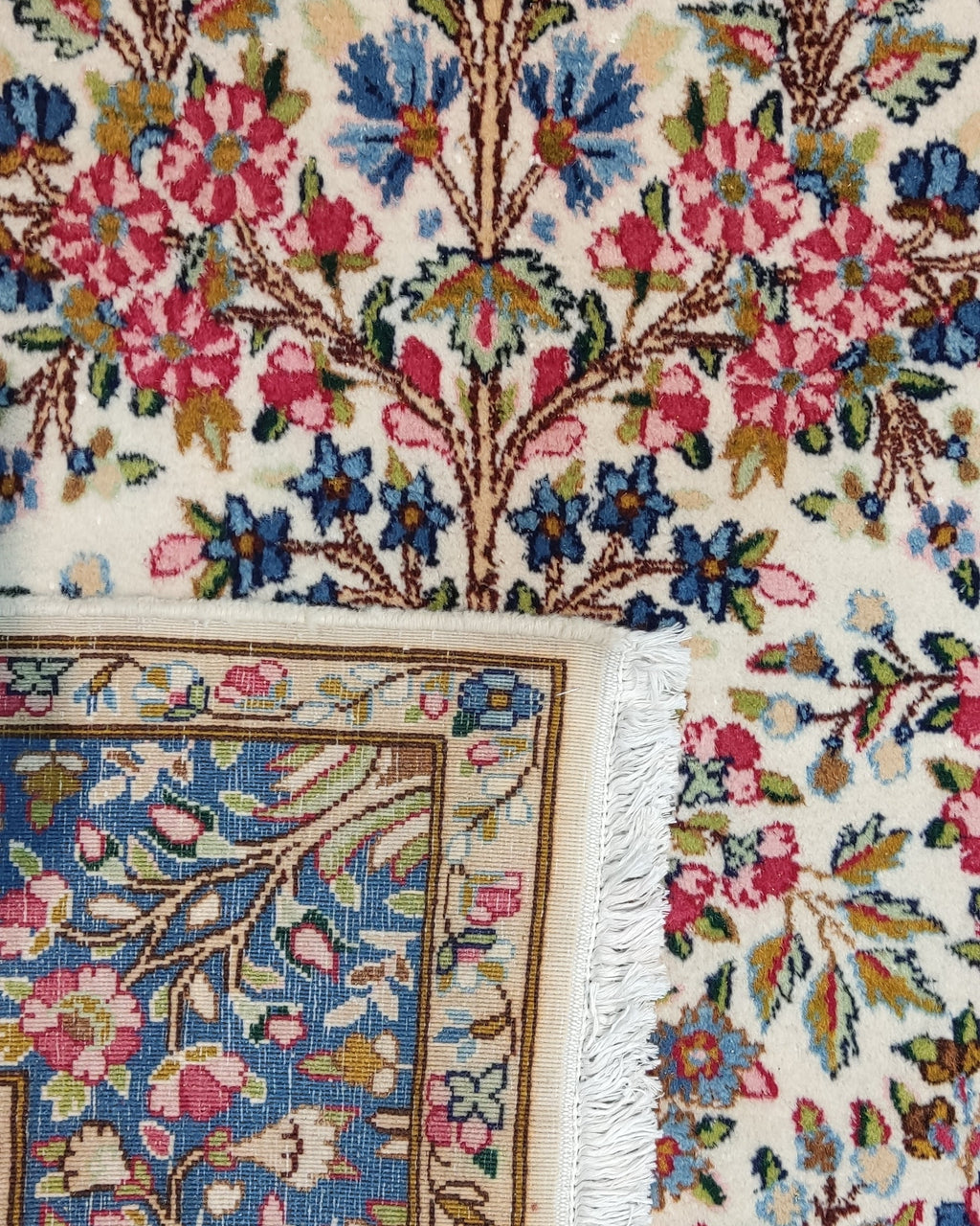 Tappeto persiano Kerman annodato a mano con albero della vita e ricchi motivi floreali nei toni dell'avorio, blu e rosa, misura 245x150 cm