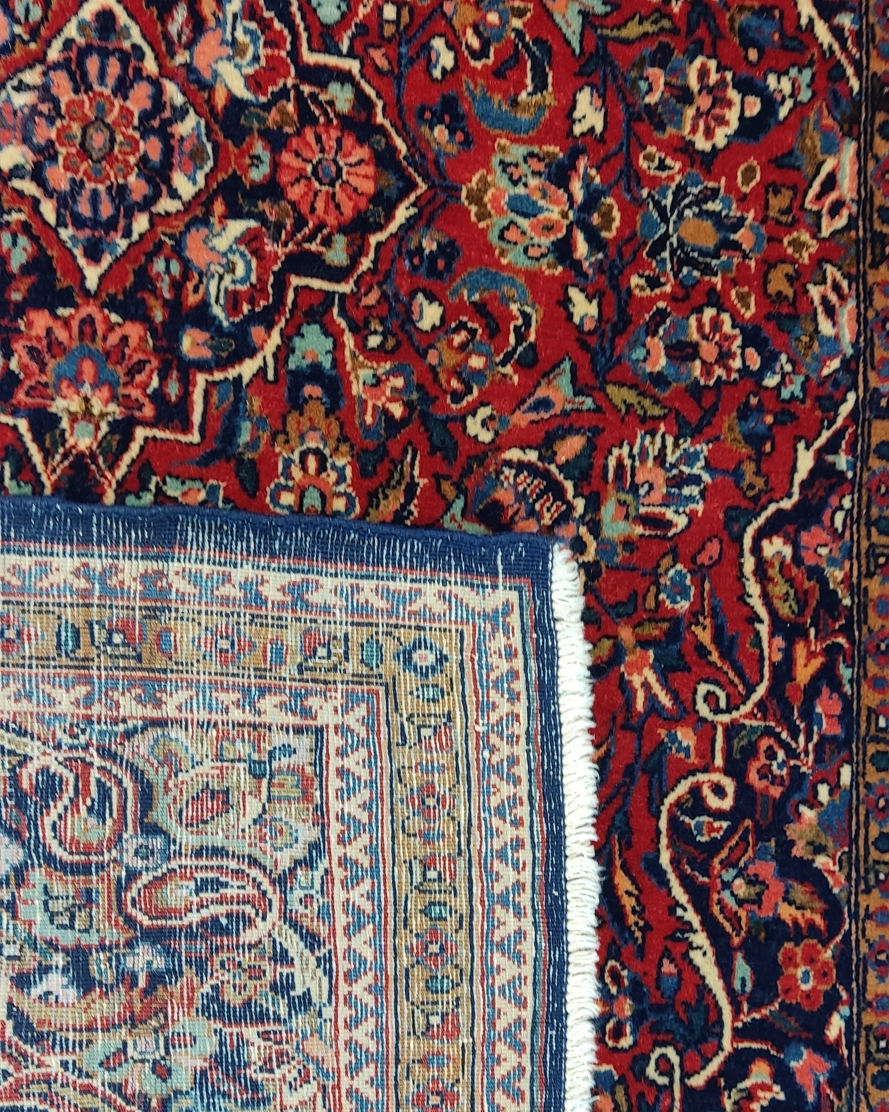 Tappeto persiano Kashan antico annodato a mano con ricchi motivi floreali su fondo rosso e bordura blu, misura 200x128 cm