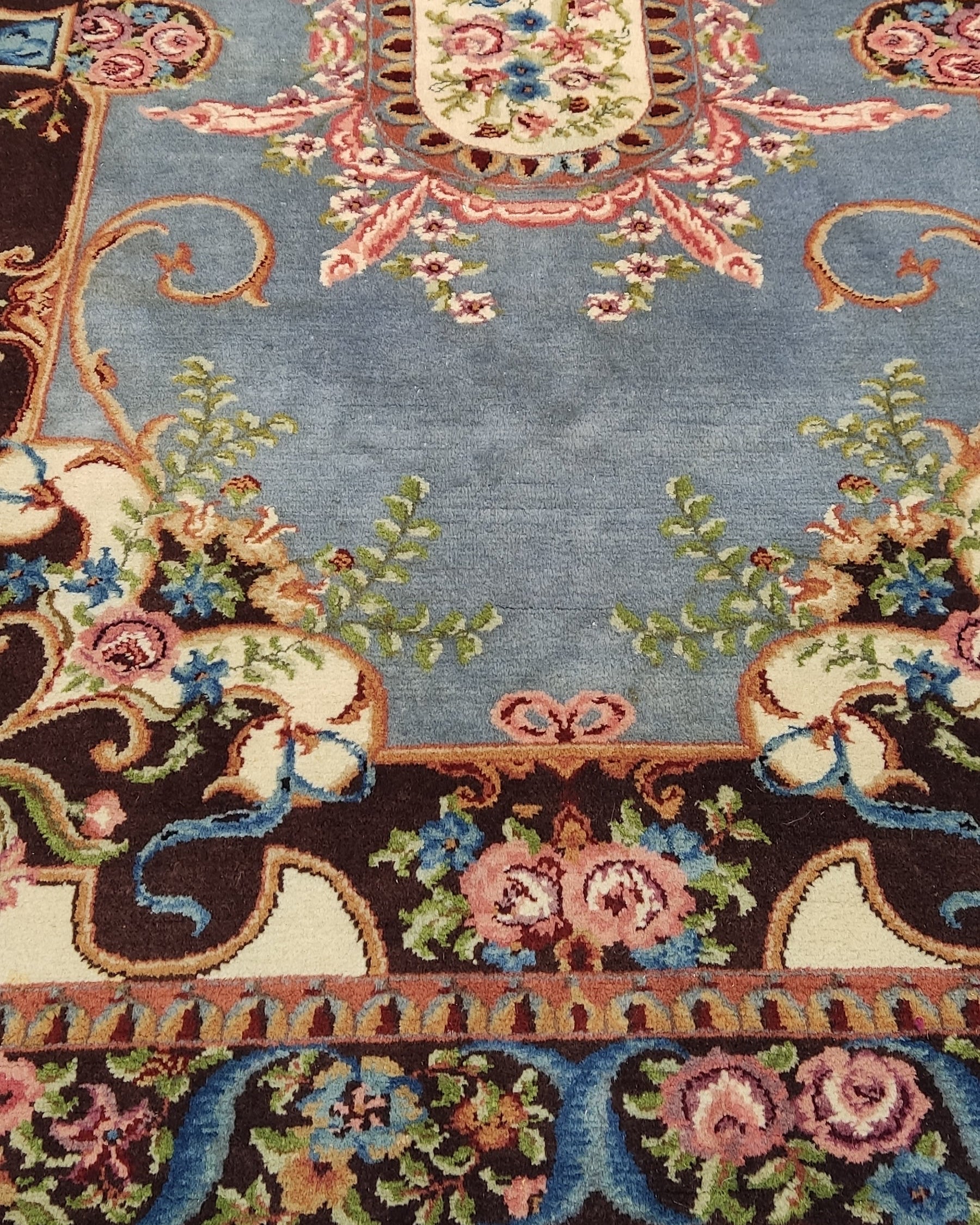 Tappeto Rumeno annodato a mano 252x178 cm con fondo azzurro, medaglione centrale e raffinati motivi floreali.
