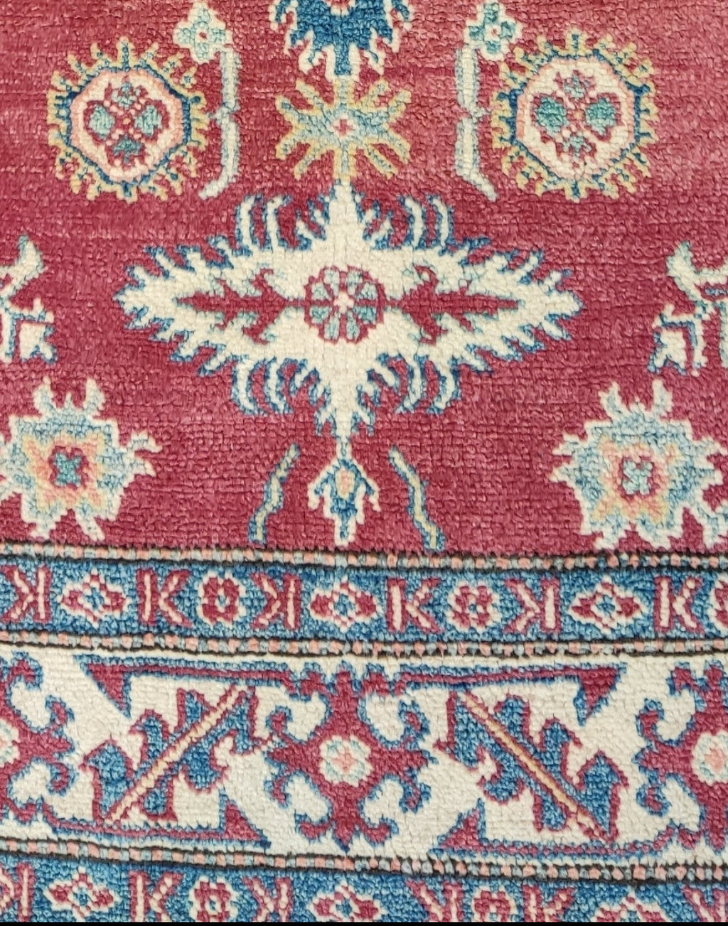 Tappeto Uzbek annodato a mano con fondo rosso rubino e motivi geometrici caucasici nei toni dell'avorio e dell'azzurro, misura 158x108 cm