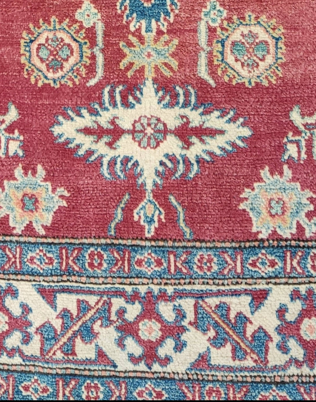 Tappeto Uzbek annodato a mano con fondo rosso rubino e motivi geometrici caucasici nei toni dell'avorio e dell'azzurro, misura 158x108 cm